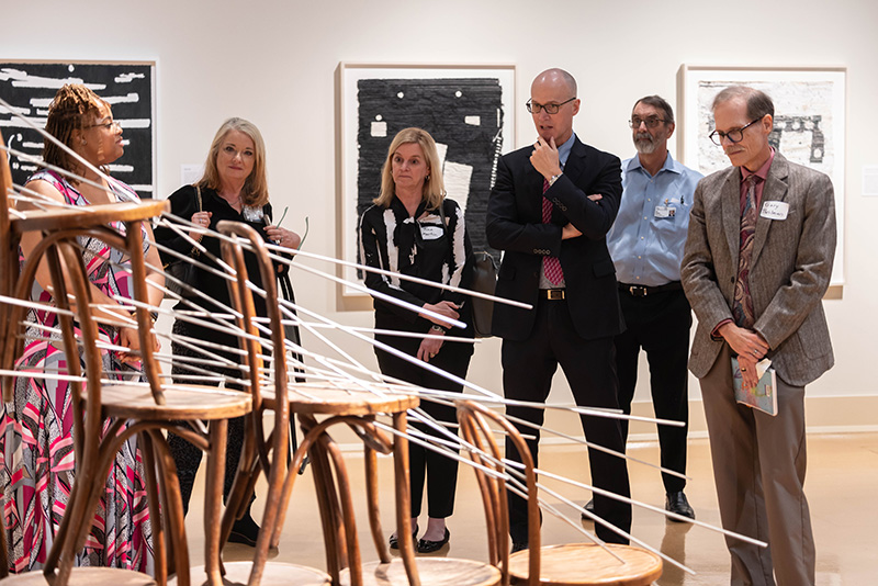 Detrice Roberts, left, a tour guide at the Mississippi Museum of Art, explains aspects of the Lights from the Garden sculpture as Dr. Margaret Calcote, director of the School of Nursing, Dr. Tina Martin, associate dean of the School of Nursing, Dr. Scott Rodgers, associate vice chancellor, Dr. Rob Rockhold, professor emeritus in the School of Medicine and Dr. Gary Theilman with the School of Pharmacy listen and study the piece during the UMMC Academy for Excellence in Education's event at the museum.